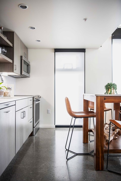 A kitchen with a table and chairs.