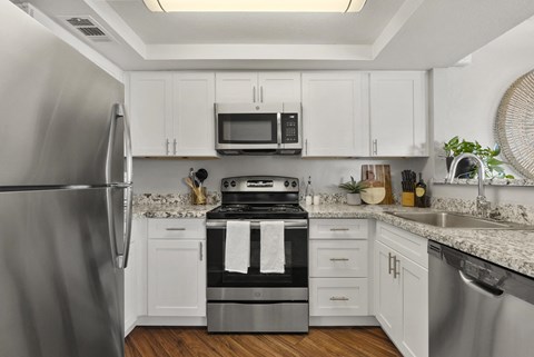 a kitchen with stainless steel appliances and white cabinets