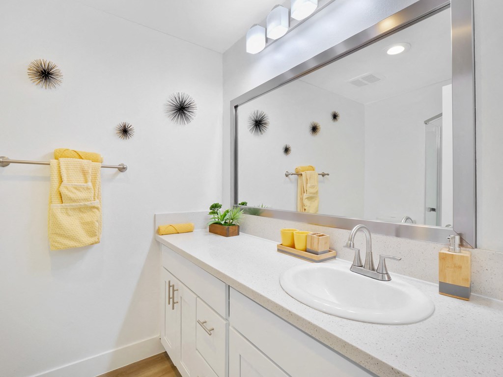 A bathroom with a white sink and a mirror at Verandas Apartments, West Covina