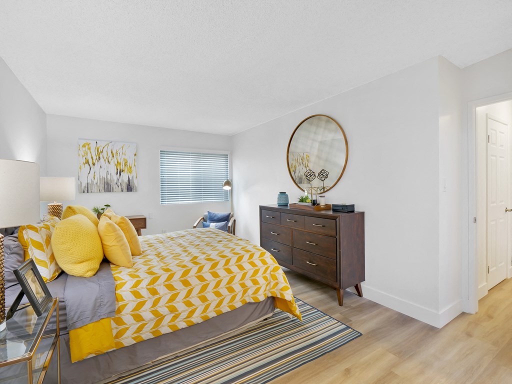 A bedroom with a bed, dresser, and mirror at Verandas Apartments, West Covina, CA, 91791