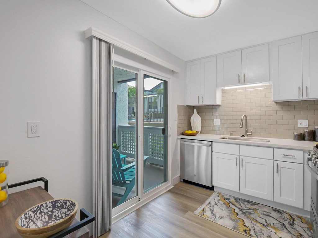 A kitchen with white cabinets and a marble floor at Verandas Apartments, California, 91791