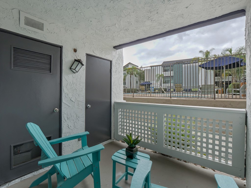 A balcony with a white railing and a black door at Verandas Apartments, West Covina, 91791