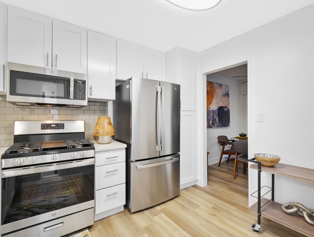A kitchen with a stove, microwave, and refrigerator at Verandas Apartments, California, 91791
