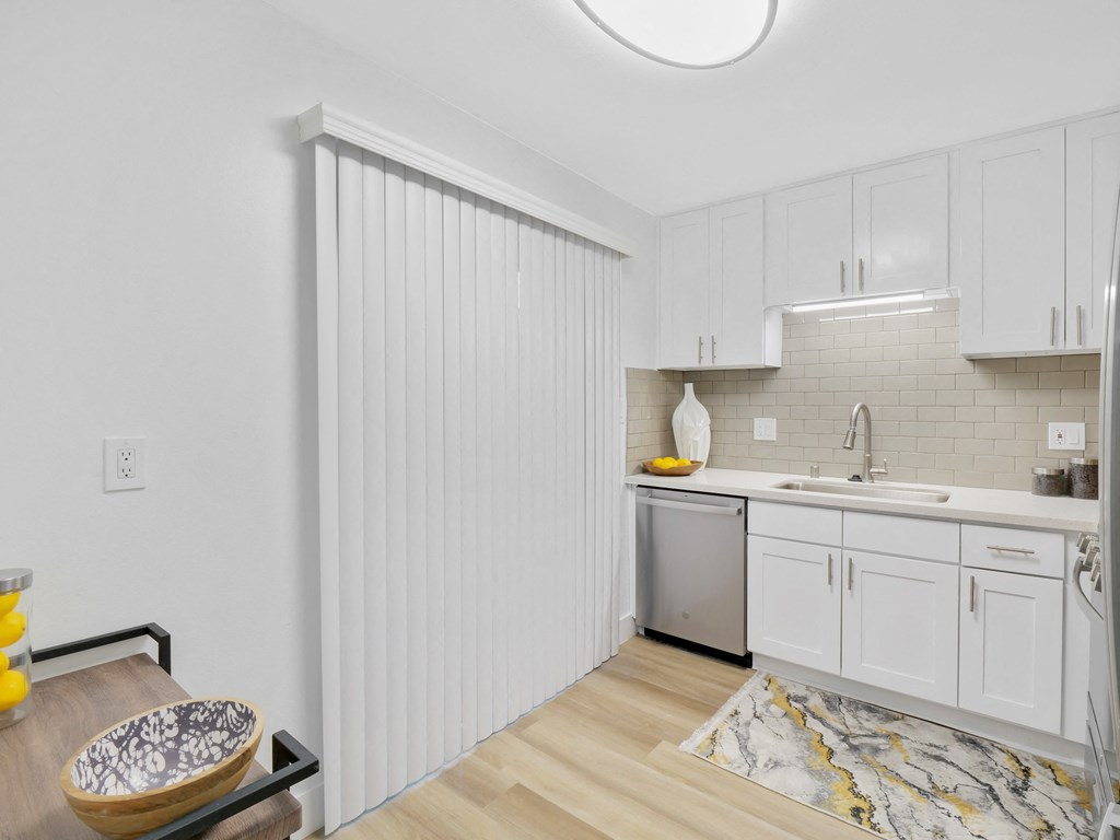 A kitchen with white cabinets and a marble patterned rug at Verandas Apartments, West Covina, CA, 91791
