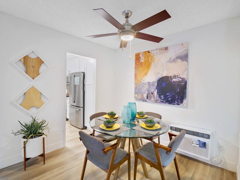 A dining room with a glass table and chairs at Verandas Apartments, West Covina