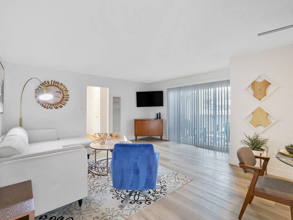 A living room with a white sofa, a blue chair, and a wooden cabinet at Verandas Apartments, California, 91791