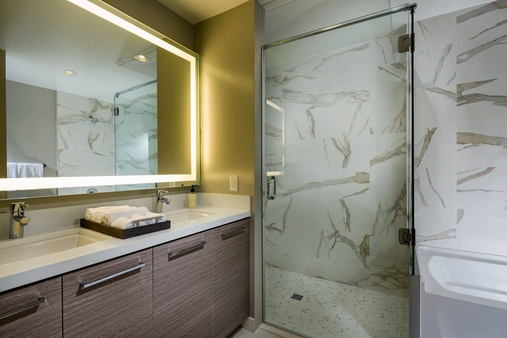A bathroom with a marble patterned shower door.at Chelsea Santa Monica, Santa Monica  