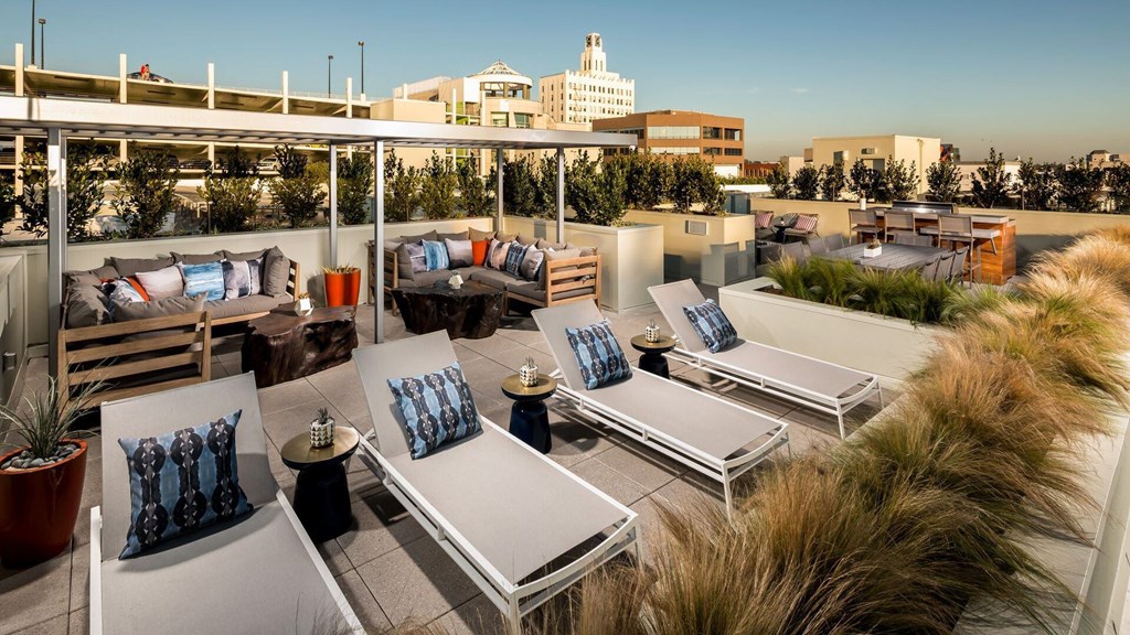 A rooftop patio with lounge chairs and cushions overlooking a cityscape.at Chelsea Santa Monica, Santa Monica California  