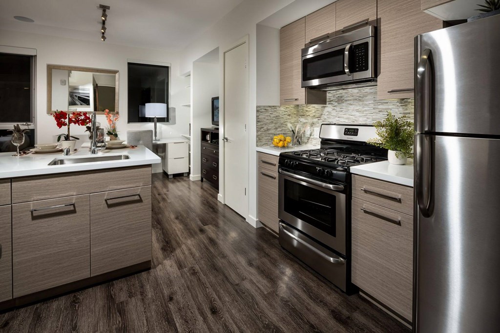 A modern kitchen with a stainless steel refrigerator and dark wood flooring.at Chelsea Santa Monica, Santa Monica, 90411  