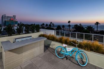 A blue bicycle is parked on a patio overlooking the ocean.at Chelsea Santa Monica, Santa Monica, 90411  
