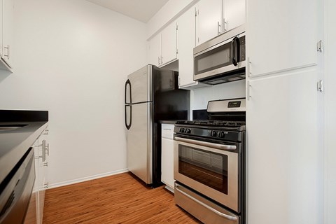 A kitchen with a black refrigerator, stove, and oven.