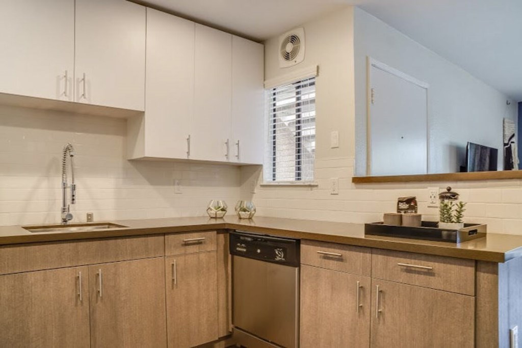 A kitchen with wooden cabinets and a stainless steel dishwasher.at Solterra At Civic Center, California, 90650-8308