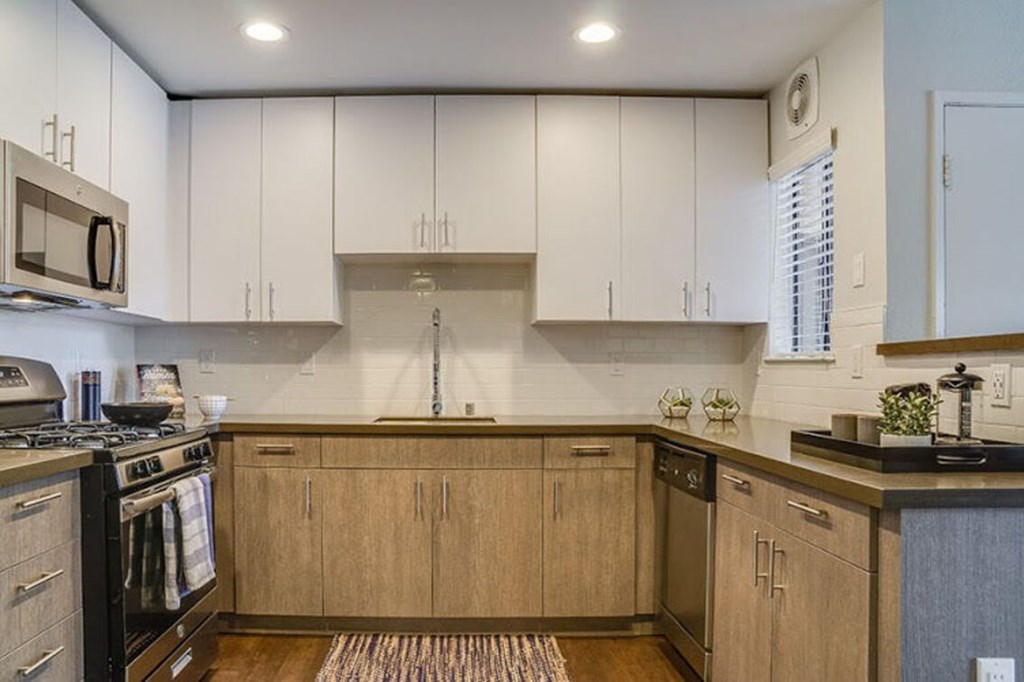 A kitchen with wooden cabinets and a black stove top oven.at Solterra At Civic Center, Norwalk, CA  