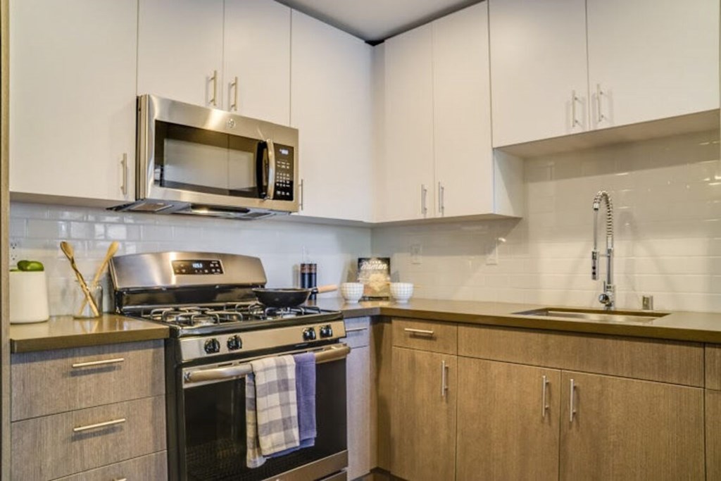 A modern kitchen with a stove, microwave, and cabinets.at Solterra At Civic Center, Norwalk  
