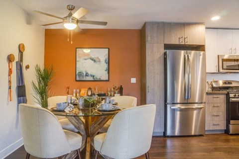 A modern kitchen with a glass dining table and chairs.