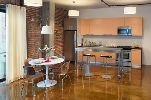 A kitchen with a table and chairs in front of a brick wall.