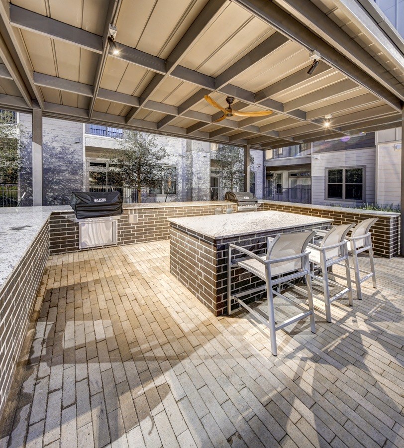 a patio with a bar and a grill at Arise Riverside, Austin, TX 
