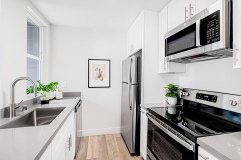 A modern kitchen with stainless steel appliances and white cabinets.