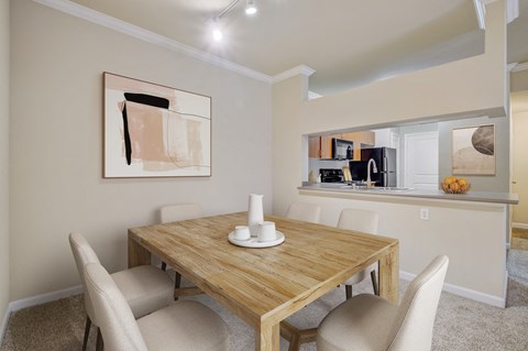 2 Bedroom Apartments in North Sacramento, CA - Avanti - Dining Area with Carpet Flooring, Table, Chairs, 9-foot Ceiling, Track Lighting, and View of Kitchen.