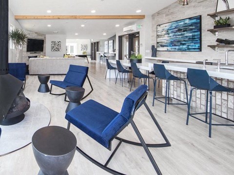 Lofts for Rent in North Seattle, WA - Origin - Resident Lounge With Blue Accent Chairs, Fireplace, Bar Seating, Built-In Shelving, And Open Social Areas.