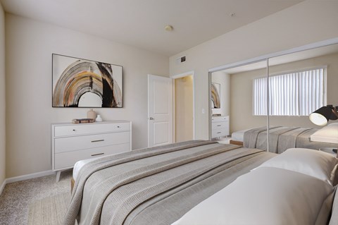 3-Bedroom Apartments in Sacramento, CA - Avanti - Bedroom with Plush Carpeting, Full-Size Bed, Dresser, Double Mirror Closet Doors, and Wall Art