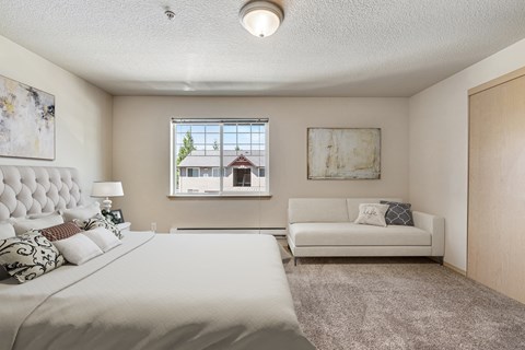 A bedroom with a large bed and a couch.
