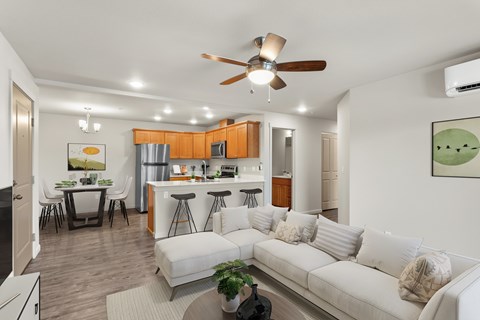 A modern living room with a white couch and a ceiling fan.