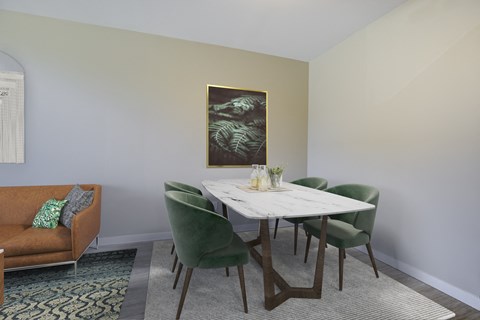 A dining room with a white table and green chairs.