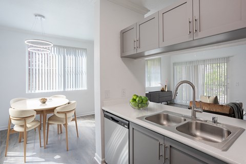A kitchen with a dining table and chairs.