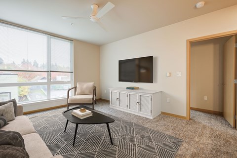 A living room with a black coffee table and a white entertainment center.