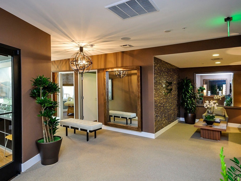 a large lobby with benches and plants and a glass door