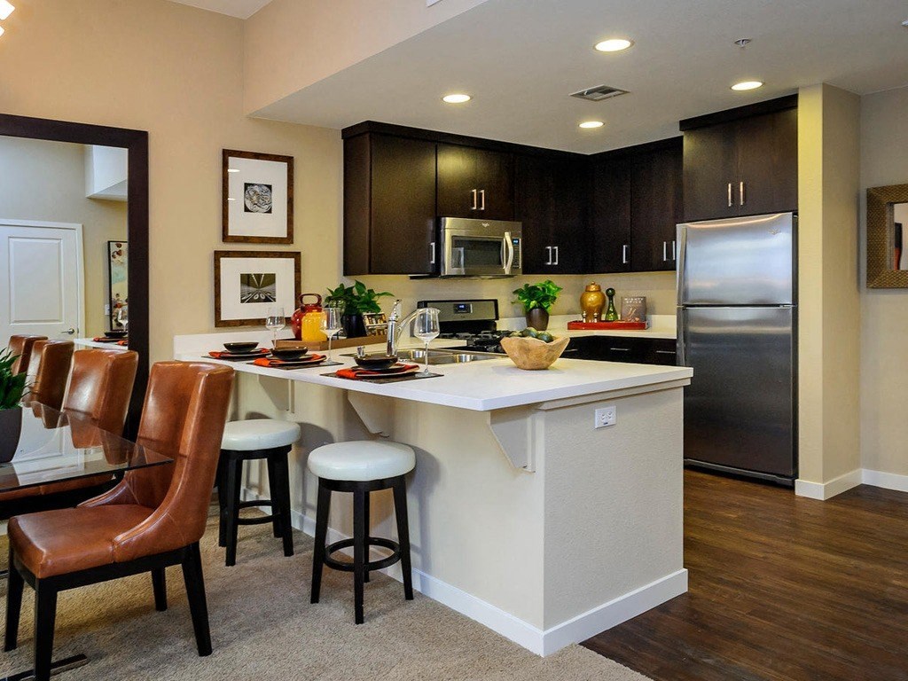 a kitchen with a center island and a stainless steel refrigerator