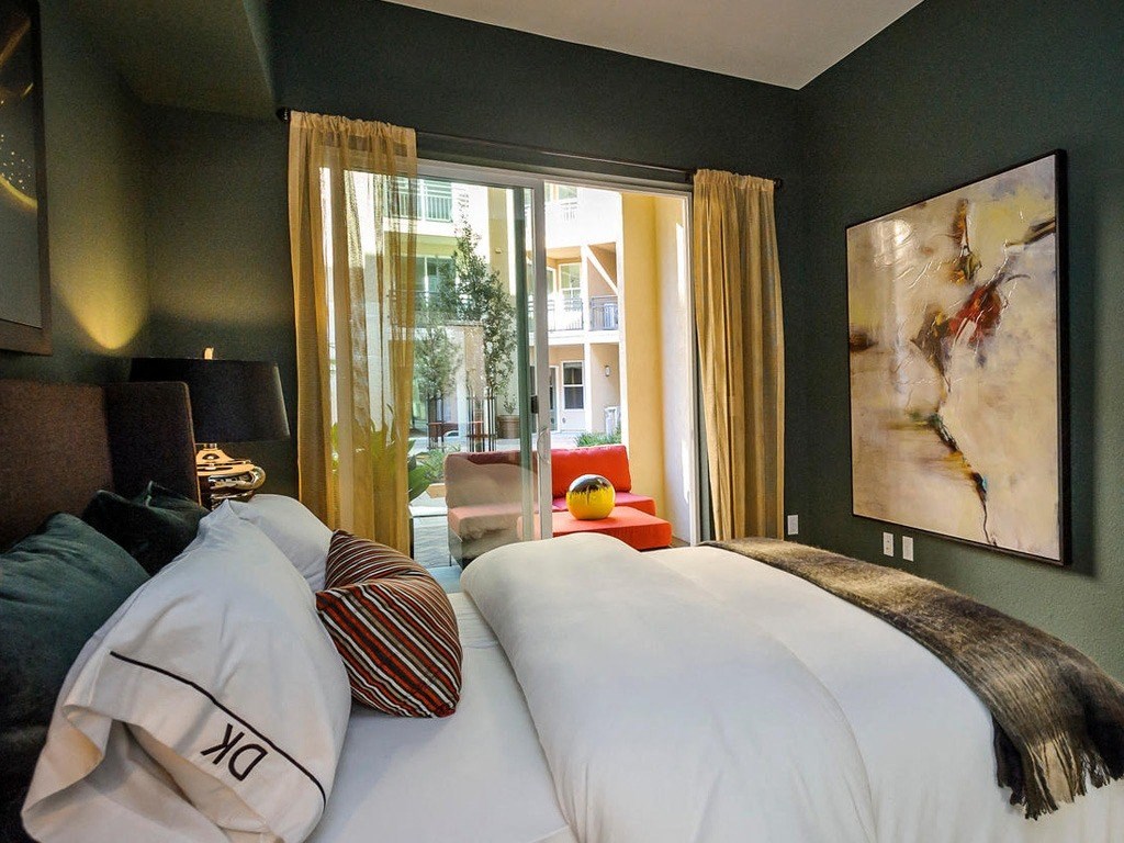 a bedroom with a bed and a large window