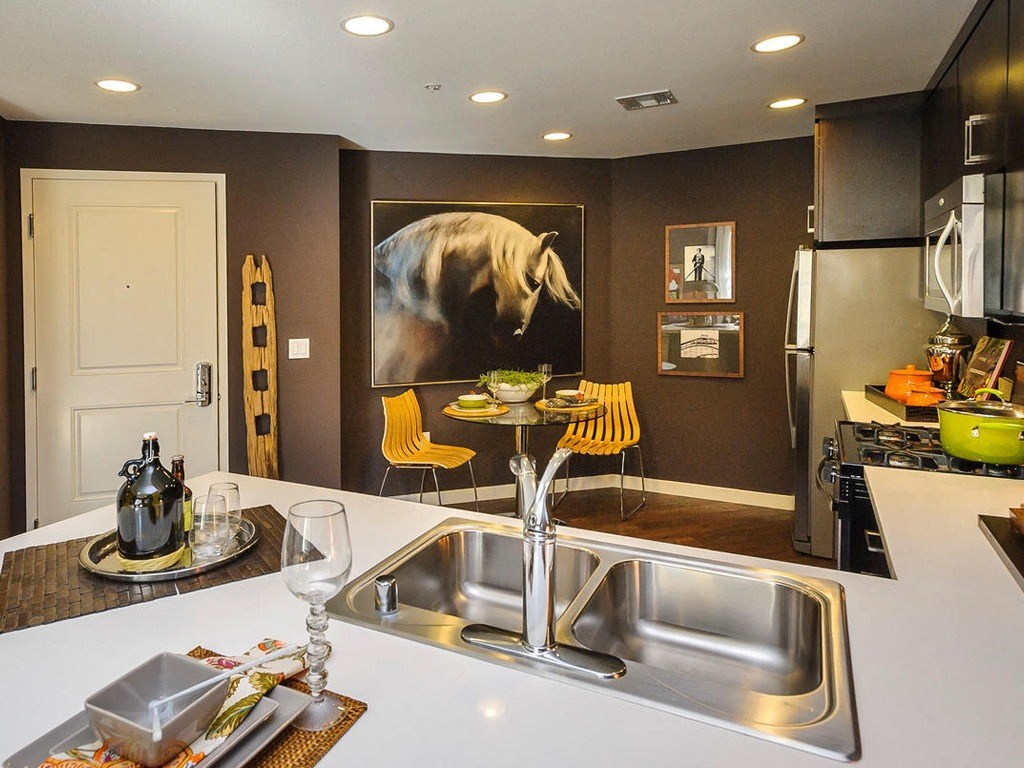 a kitchen with a sink and a painting of a horse