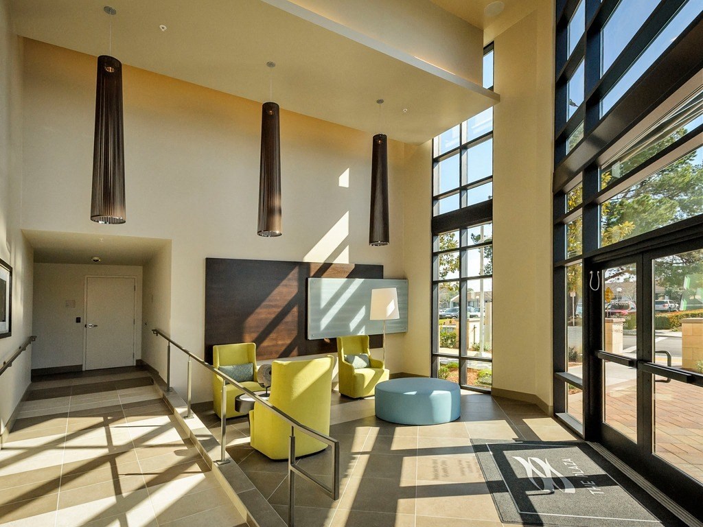 a living room with yellow furniture and large windows