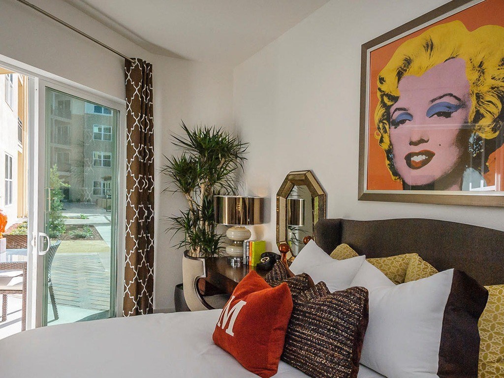 a bedroom with a large bed and a painting on the wall