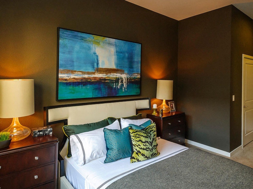 a bedroom with a bed and a painting on the wall