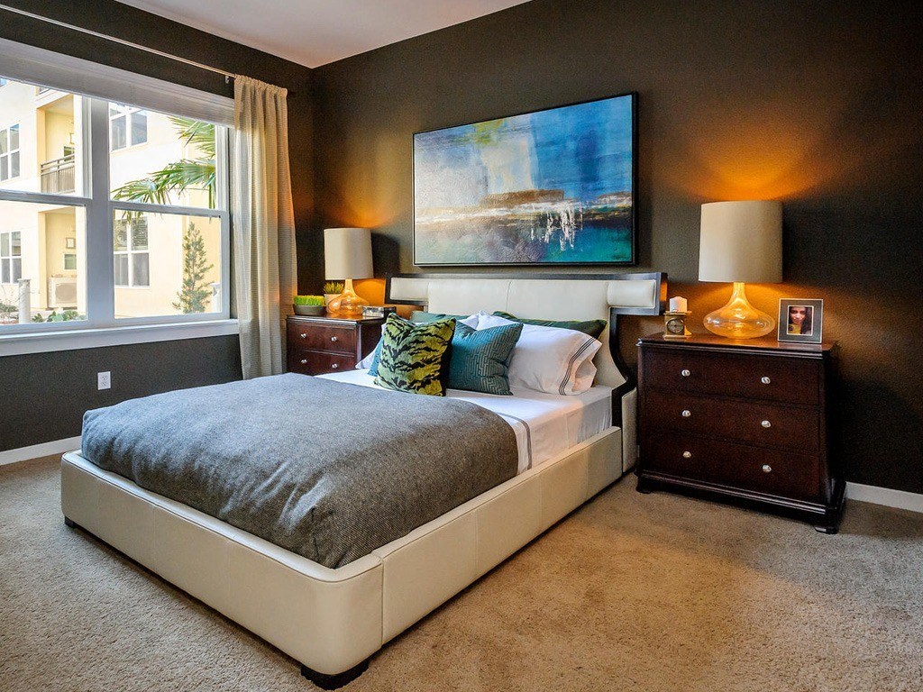 a bedroom with a bed and a painting on the wall