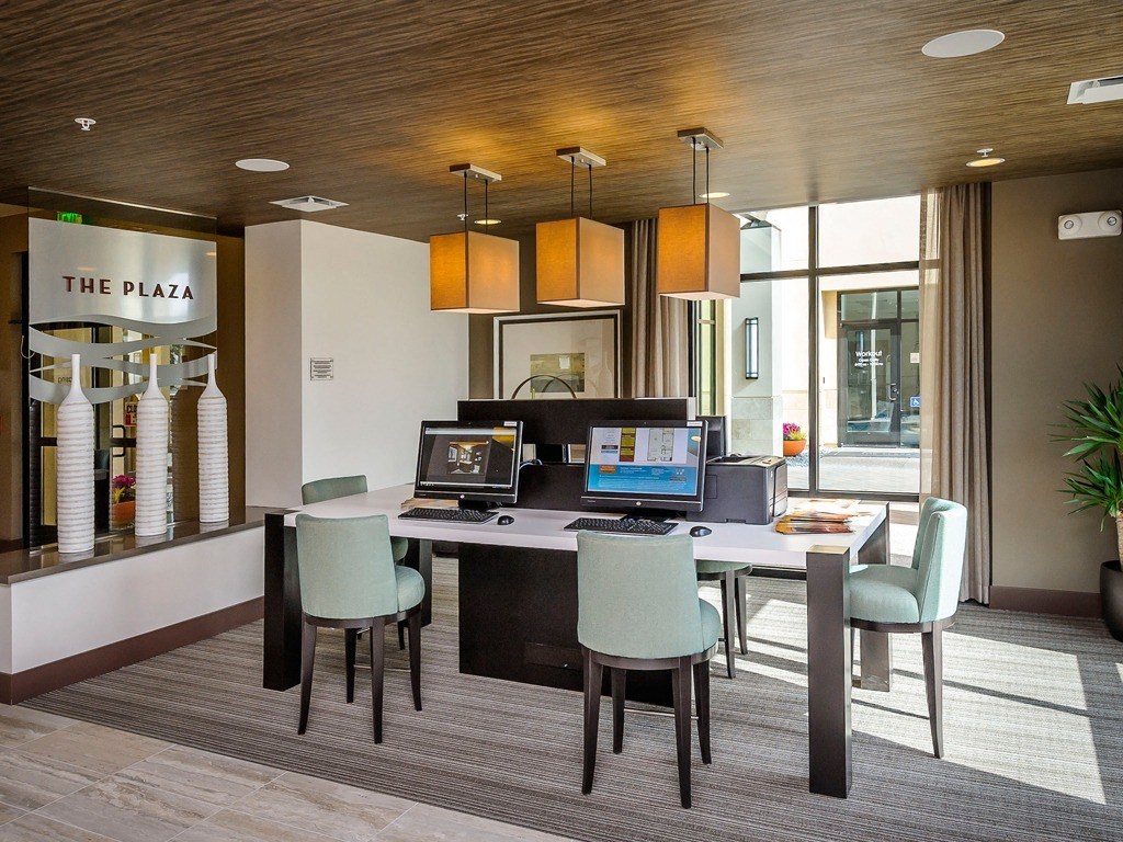 an office with a desk with a laptop and a computer on it