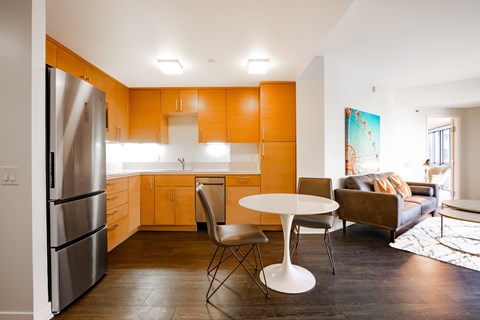 A kitchen with orange cabinets and a white table.