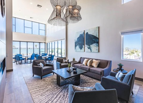 A modern living room with a large window and a painting on the wall.