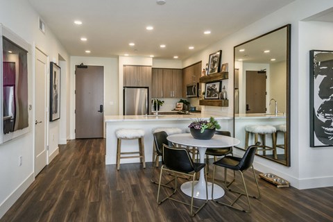 A modern kitchen with a dining table and chairs.