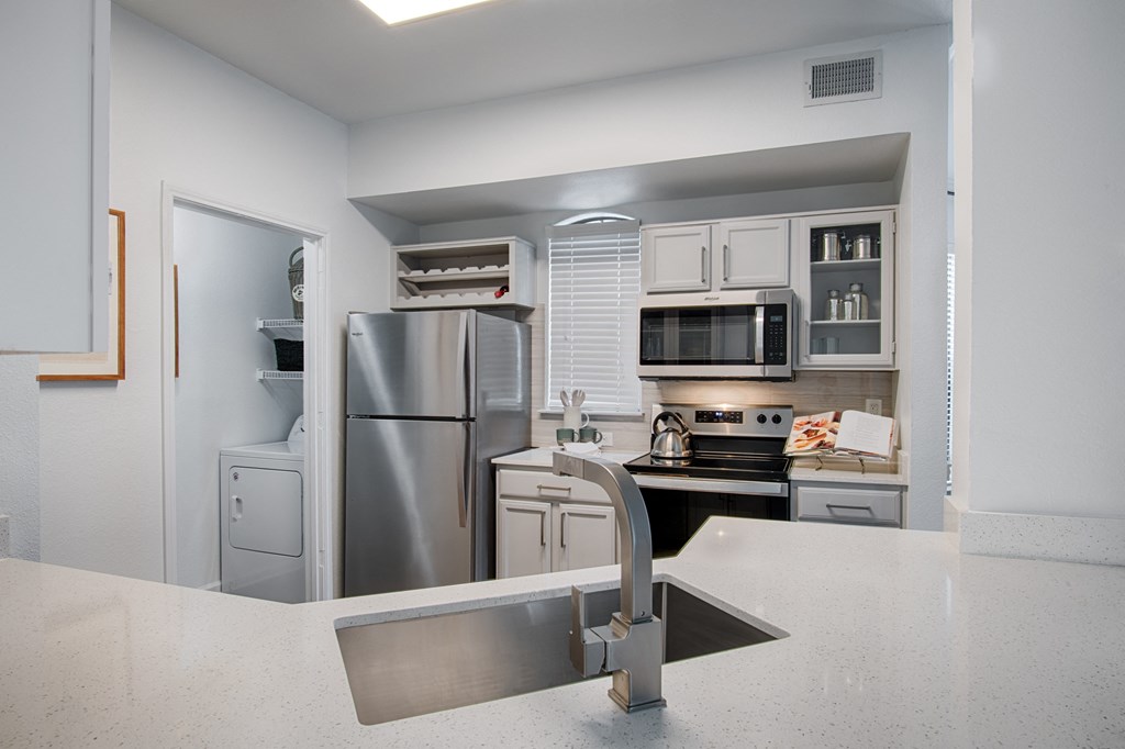 a kitchen with white cabinets and stainless steel appliances