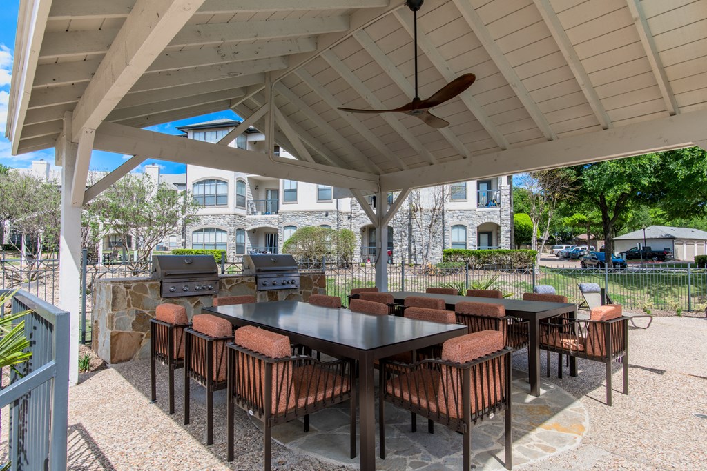 Covered patio with tables and chairs and a grill Covered patio with tables and chairs and a grill at Silverado, Frisco, TX, Texas, 75034