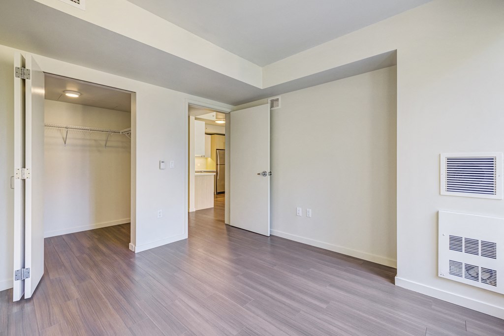 unfurnished bedroom with wood plank style flooring and walk in closet