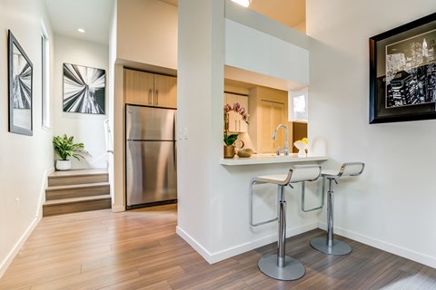a kitchen with a bar and a stainless steel refrigerator