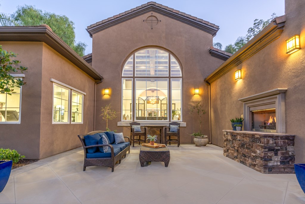 A patio with a stone fireplace and a couch.