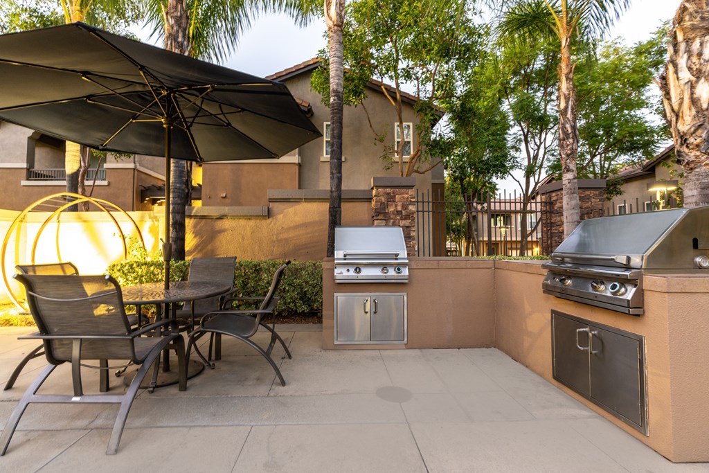 A patio with a table and chairs under an umbrella.