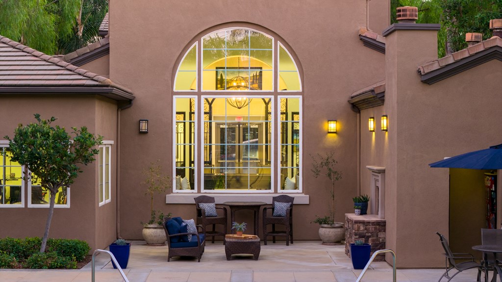 A patio with a table and chairs is set up outside a house.