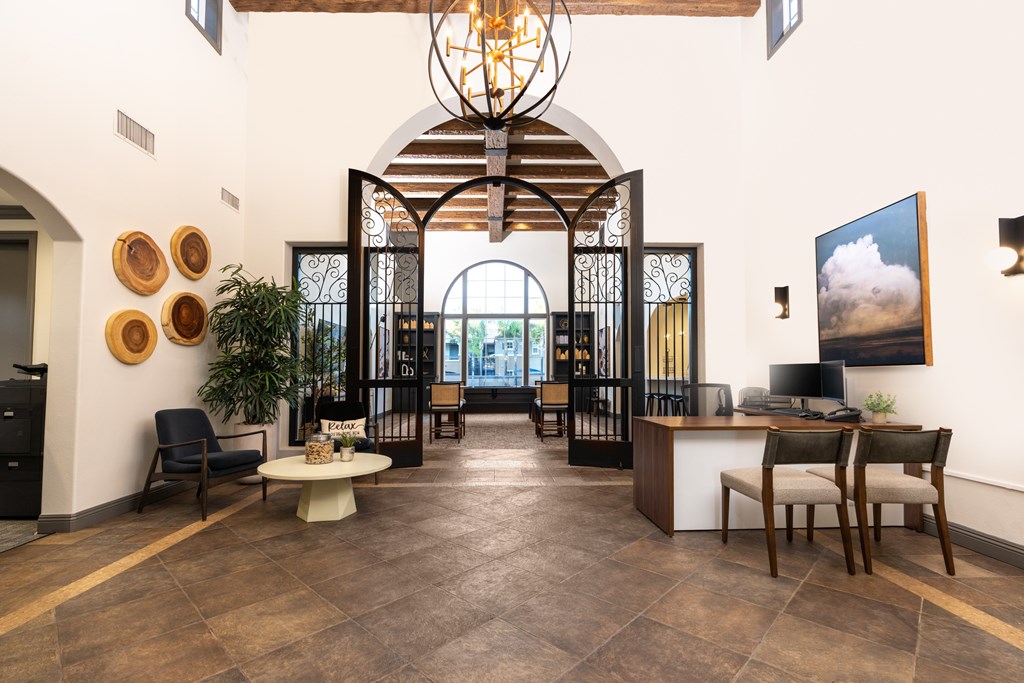 A large room with a chandelier and a long table with chairs.